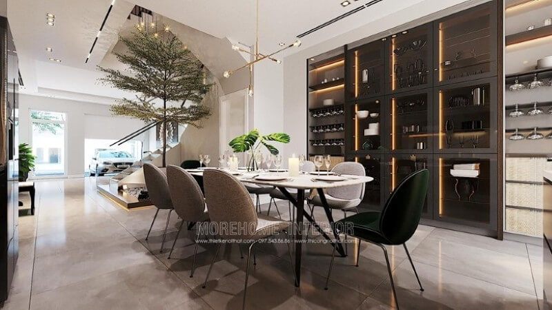 Trang trí nội thất phòng ăn đẹp với bộ bàn ăn dành cho 8 thành viên, chiếc đèn thả trần nghệ thuật, gạch lát nền giả đá màu nâu cao cấp, tủ gỗ kết hợp kính có gắn đèn led để đồ hiện đại.